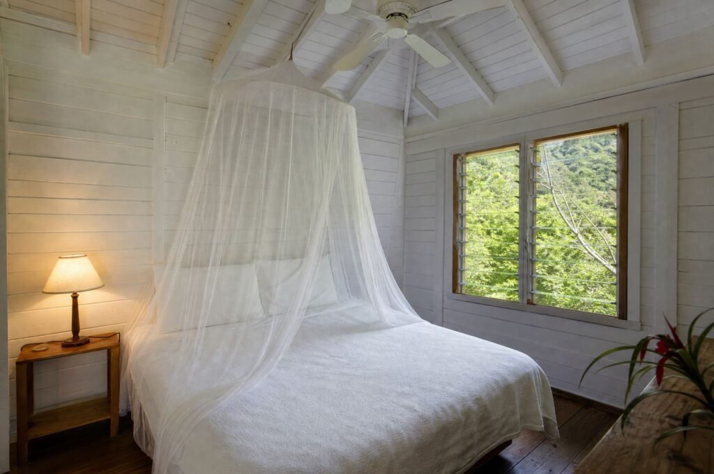 Bedroom at Almond Tree Cottage with a mosquito net and ceiling fan