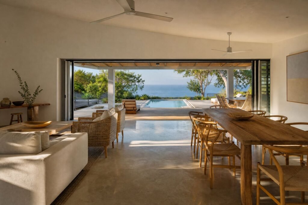 Open-plan living and dining room at Seagrape House, doors open to the terrace